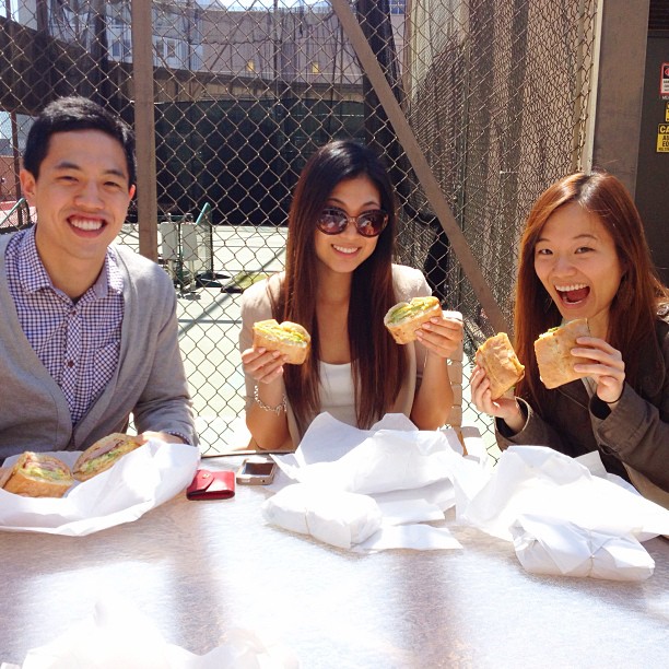 Friends enjoying Breakfast Basile sandwiches outdoors